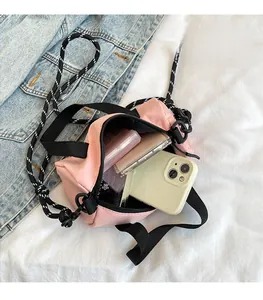 Sac bandoulière en nylon rose avec intérieur ouvert montrant le rangement du mobile