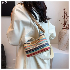 Detail of multi-color woven shoulder bag with adjustable brown leather strap and metal buckle