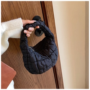 Detailed view of black quilted puffy cloud bag showing glossy texture and metal zipper