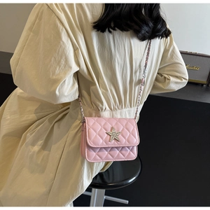 Détail du sac bandoulière matelassé rose avec boucle étoile et bandoulière chaîne