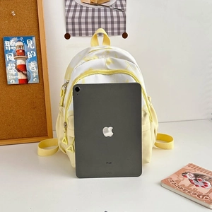 Detail view of small canvas backpack capacity showing fitting of a 9.7 inch tablet inside