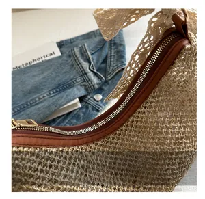 Detail of hand-woven straw bag with lace bow decoration and premium metal zipper closure