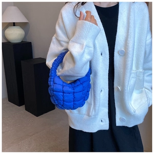 Close-up of electric blue quilted cloud bag showing puff texture and padded handle