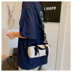 Sac Boston blanc porté en bandoulière avec des sangles noires contrastées pour femme
