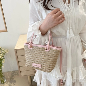 Détail de la poignée en similicuir rose et texture tissée sur un sac à main chic