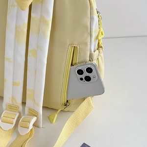 Detail view of the nylon backpack side pocket fitting a large smartphone with tie-dye strap
