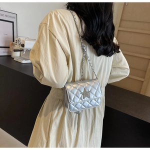 Détail du mini sac argenté matelassé avec étoile scintillante et bandoulière chaîne