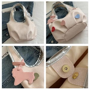 Détails de broderie florale et breloque rose sur le sac à bandoulière en toile