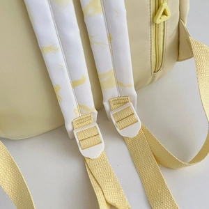Detail of thickened shoulder straps and plastic adjustment buckle on a nylon backpack
