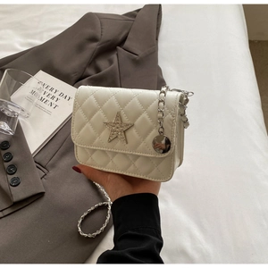 Gros plan d'un sac à bandoulière matelassé blanc avec étoile pailletée et chaîne dorée