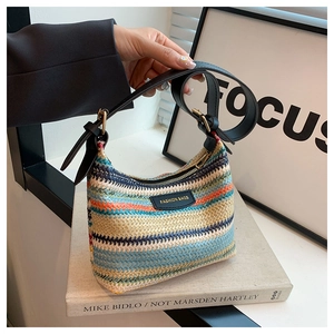 Detail of colorful rainbow woven bag texture with black leather logo and adjustable strap