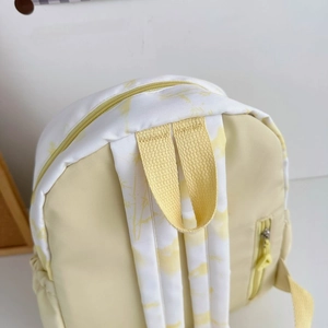Close-up of lightweight nylon backpack with yellow floral print and padded straps