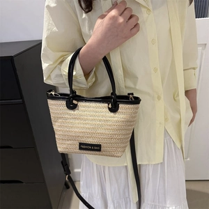 Détail du sac cabas en paille tressée avec bordure en cuir noir et étiquette