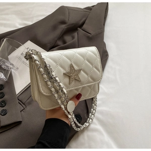 Détail du sac bandoulière matelassé blanc cassé avec étoile diamantée et chaîne