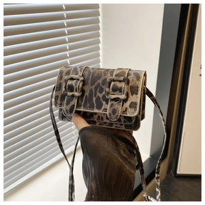 Vue détaillée du mini sac bandoulière léopard en cuir texturé avec boucles décoratives