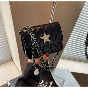 Détail du sac matelassé noir avec une étoile scintillante et une bandoulière chaîne