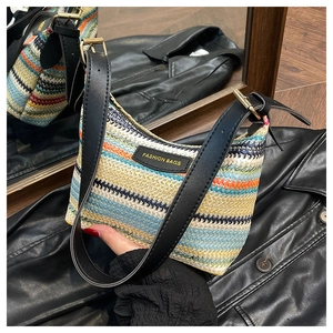 Detail of colorful woven straw bag with adjustable black leather strap and metal buckle