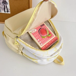 Detail view of the spacious main compartment of this yellow nylon backpack for students