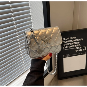 Détail du sac carré argenté matelassé avec étoile scintillante et bandoulière en chaîne
