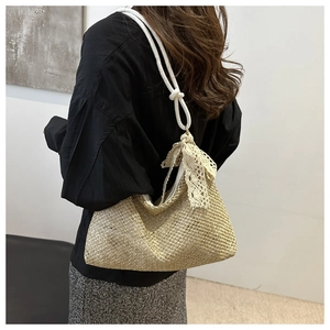 Detail of woven straw bag texture with elegant cream lace bow and white rope strap