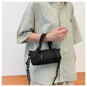 Sac Boston noir tendance avec bandoulière corde et étiquette de marque sur un modèle