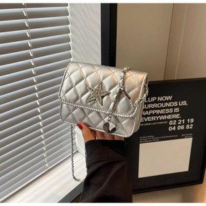 Détails du mini sac argenté matelassé avec étoile en diamant et bandoulière chaîne