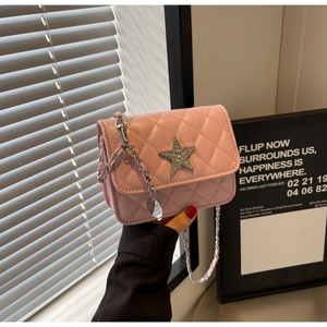 Détail du sac bandoulière matelassé rose avec étoile argentée et bandoulière chaîne