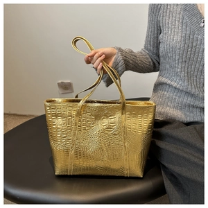 Detailed macro view of the gold crocodile embossed texture on a retro tote handbag