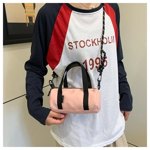 Mini sac cylindre en nylon rose avec bandoulière en corde réglable porté par un mannequin