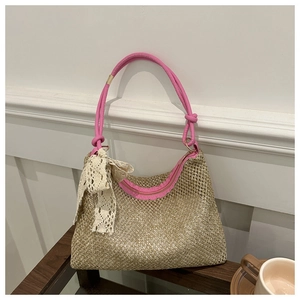 Close-up of woven straw bag with pink leather handles and delicate lace bow detail