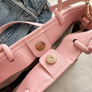 Détail du sac en cuir rose avec fermeture magnétique et doublure en tissu à chevrons