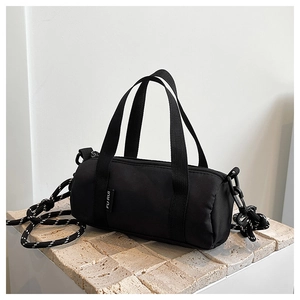 Vue détaillée du sac de voyage noir avec bandoulière en corde et étiquette de marque
