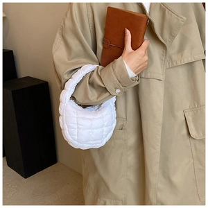 Close-up of white quilted crescent bag showing the high-quality stitching and texture