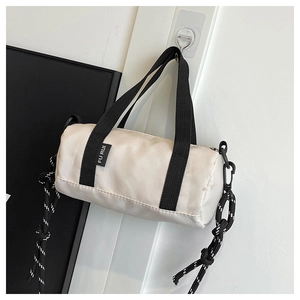 Vue détaillée du sac polochon en nylon beige avec poignées tissées et cordons de serrage
