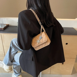 Sac bandoulière marron matelassé avec chaîne argentée et breloque étoile sur mannequin
