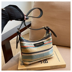 Detailed close-up of rainbow striped woven bag with leather strap and fashion label