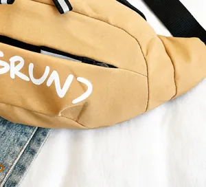 Close-up of khaki outdoor chest bag featuring durable fabric and reflective zip detail