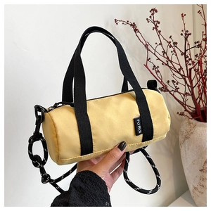Détail d'un sac polochon jaune vif avec une bandoulière en corde tressée robuste