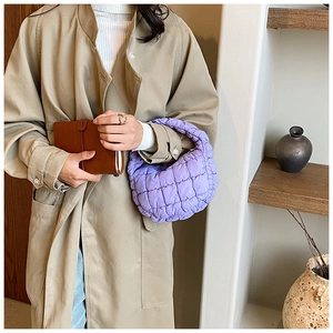 Detail of a purple quilted cloud bag made of nylon shown as a stylish handbag accessory