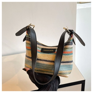 Detailed close-up of rainbow woven texture and black leather fashion label on handbag