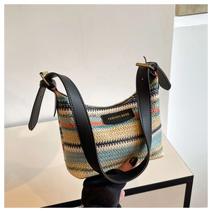 Close-up of rainbow woven texture and black leather strap with gold buckle on shoulder bag