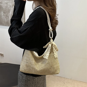 Chic woven straw shoulder bag with white rope handles and lace bow detail for summer beach