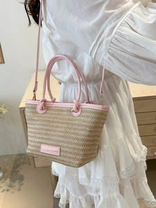 Détail du sac cabas en paille tressée avec finitions et poignées en cuir rose