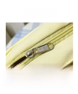 Detailed close-up of the smooth metal zipper closure on this cute yellow tote bag for women
