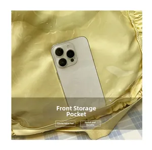 Detail view of the yellow tote bag featuring a clear front pocket for smartphone storage
