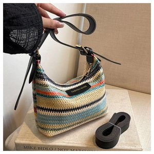 Detail of colorful woven shoulder bag with leather strap and fashion label on art book