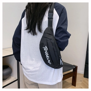 Detalle del bolso de pecho de nailon negro con letras blancas y hebilla de ajuste fuerte