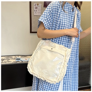Detail of canvas tote bag with transparent front window and elegant ruffled edges