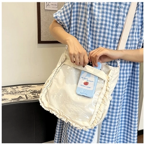 Detail of the white canvas bag with a clear PVC window and elegant ruffled decorative edges