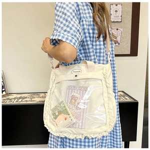 Detail of a beige canvas tote bag with clear PVC window and cute ruffle trim for students